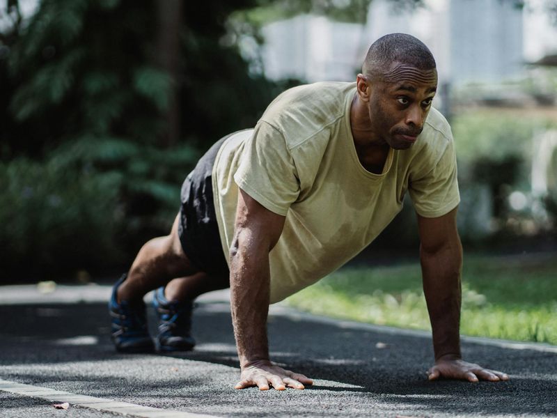 Man in a focused stance, preparing for a bodyweight exercise.